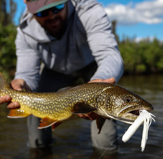 An image of a fisherman with a gorgeous fish after an Alaska fishing adventure.