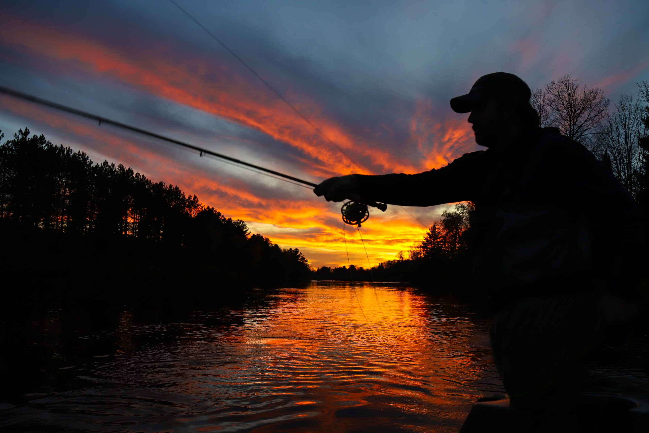 An image of a fisherman releasing a fish back into the Kenai River. 