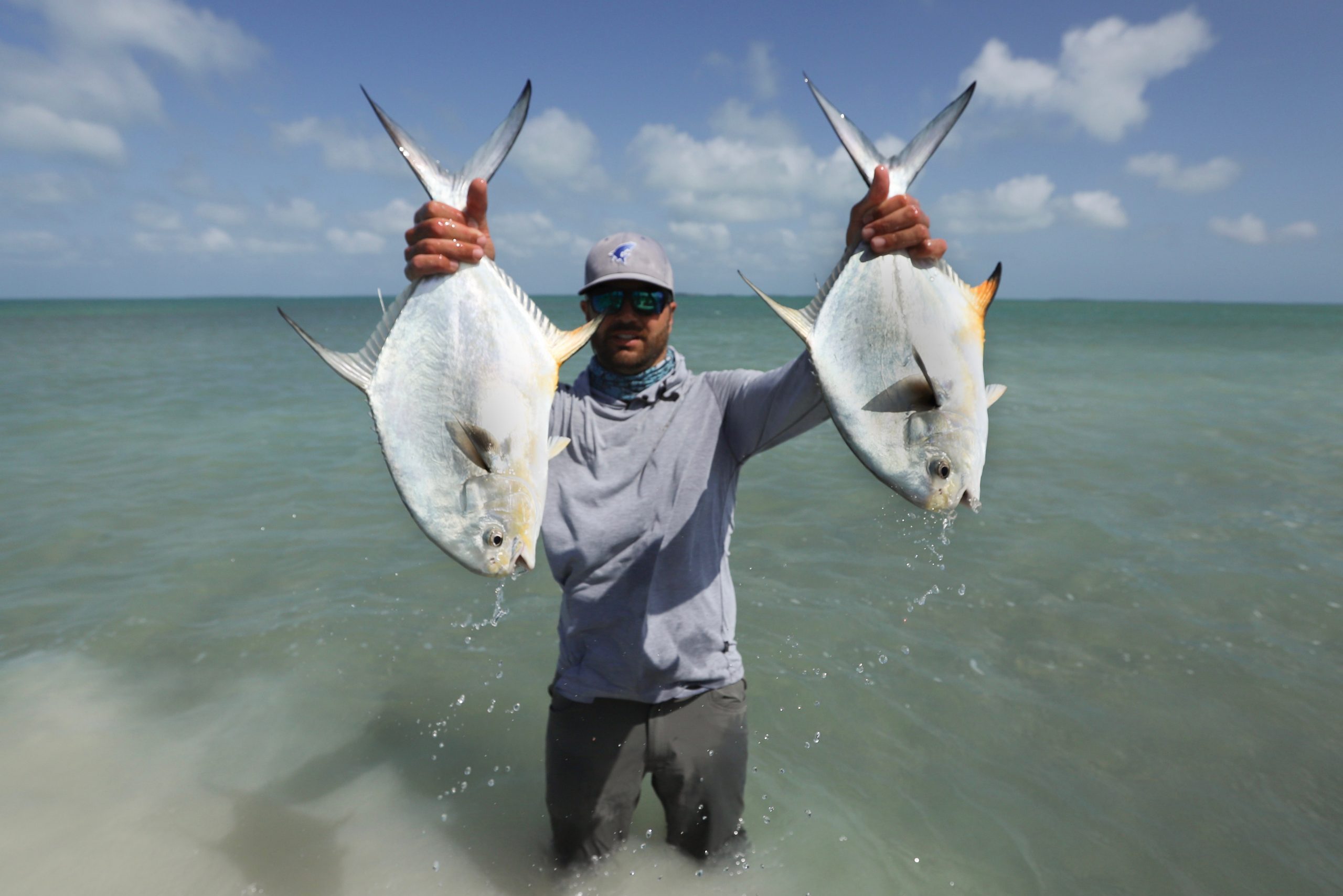 AN image of an angler holding a large permit aboard an Outgoing Angling Florida Keys Fishing Charter.
