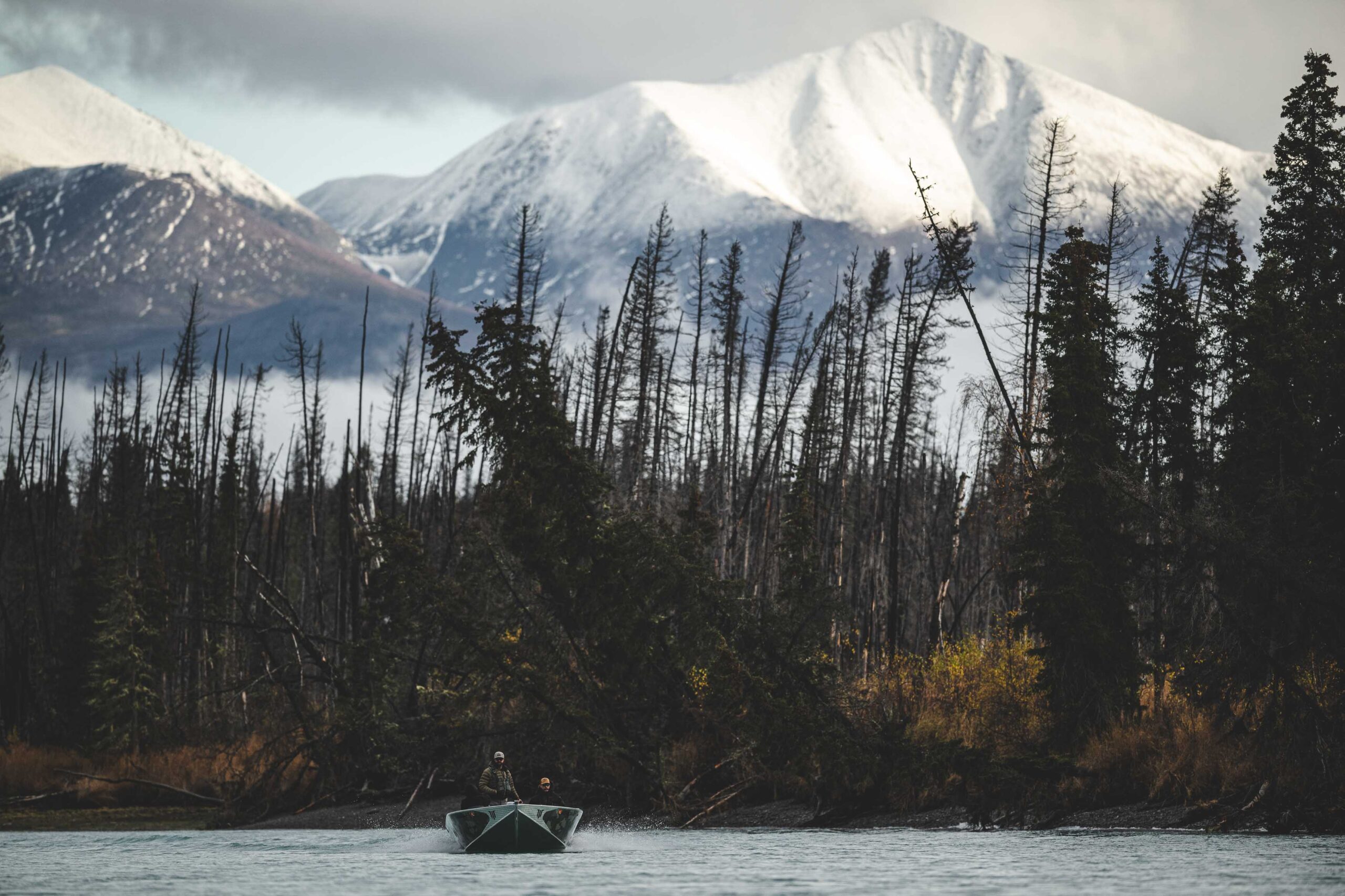 An image of a fisherman releasing a fish back into the Kenai River. 